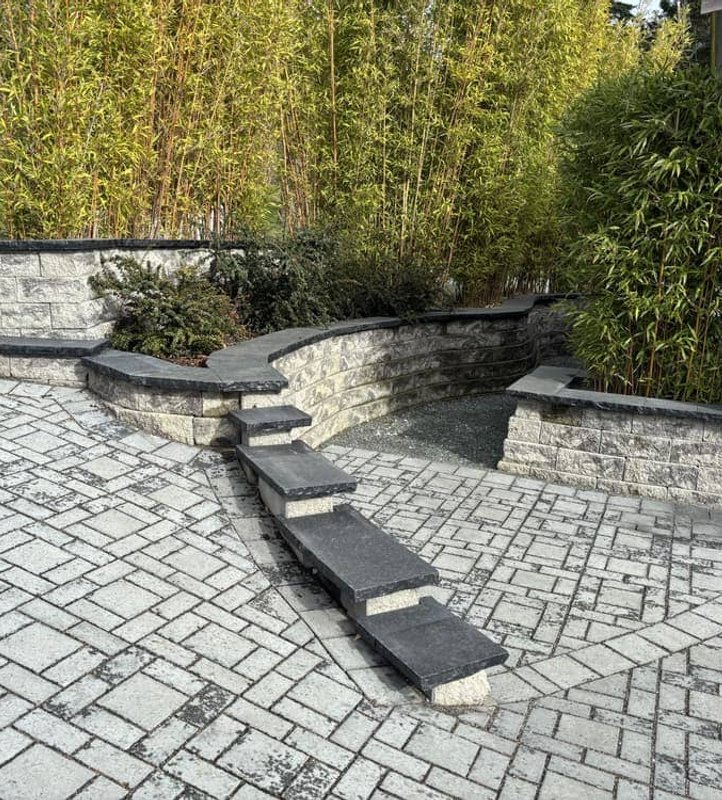 Paver patio with curved retaining wall and bamboo screen in Oak Harbor