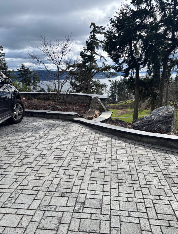 Gray paver driveway and stone wall overlooking the water on Whidbey Island