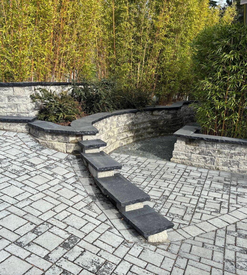 Paver patio and curved retaining wall with bamboo screening in Oak Harbor